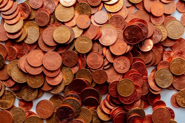 Veľká hromada medených a bronzových euromincí, väčšinou nominálnych hodnôt 1, 2 a 5 centov, roztrúsených po rovnej ploche.