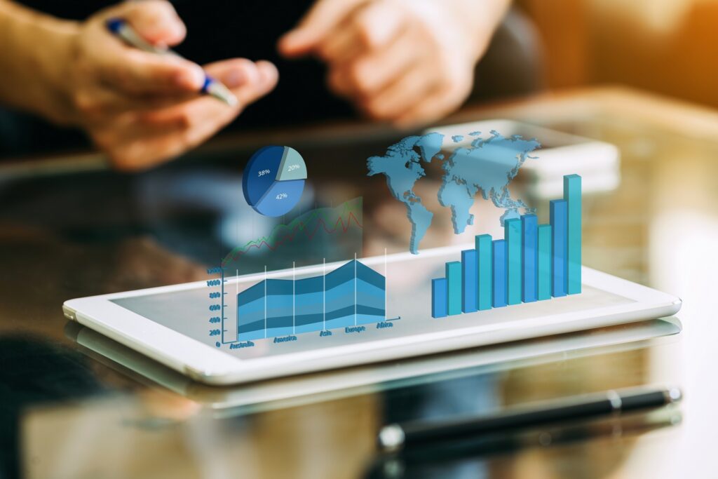Osoba komunikuje s digitálnym tabletom zobrazujúcim holografické tabuľky, grafy a mapu sveta, ktoré predstavujú analýzu obchodných alebo finančných údajov zameranú na podielové fondy v modernom prostredí.