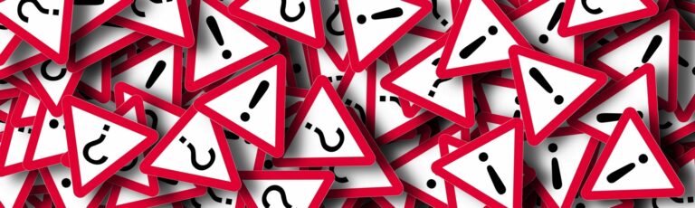 Hromada červeno ohraničených trojuholníkových výstražných značiek, niektoré s čiernymi výkričníkmi a iné s otáznikmi, sa chaoticky prekrývajú - naznačujú zmätok a riziká, ktoré sa často spájajú s úverovým podvodom.