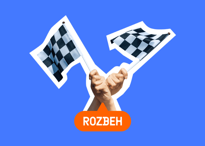 Dve ruky držiace šachovnicové vlajky sa krížia na modrom pozadí. Pod rukami je oranžový oválny tvar s nápisom ROZBEH napísaným bielymi veľkými písmenami.